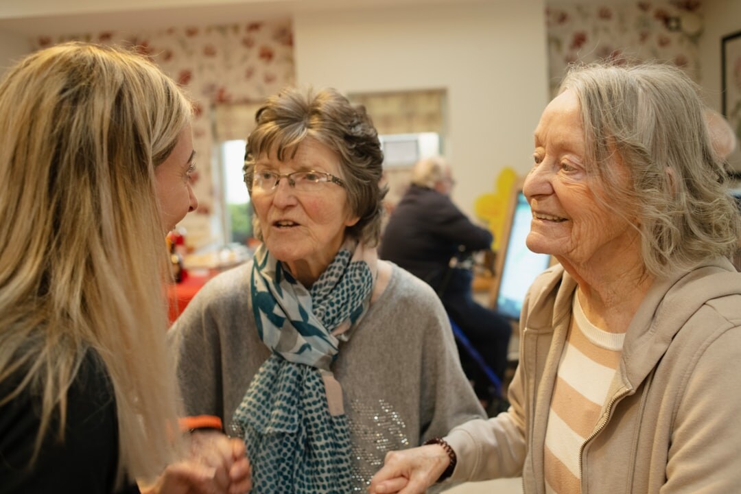 Croatian seniors gathered around a table at a community center socializing